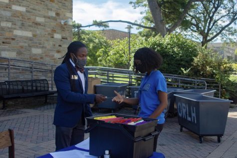 Justin Hall, Assistant Director of Student Life, assists freshman Ayona Young in checking into her dorm.