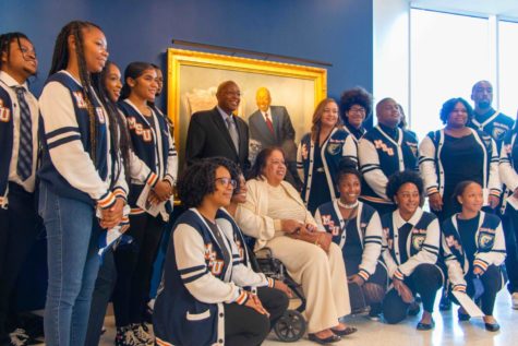 Calvin and Tina Tyler posing with their scholars in front of their portrait.