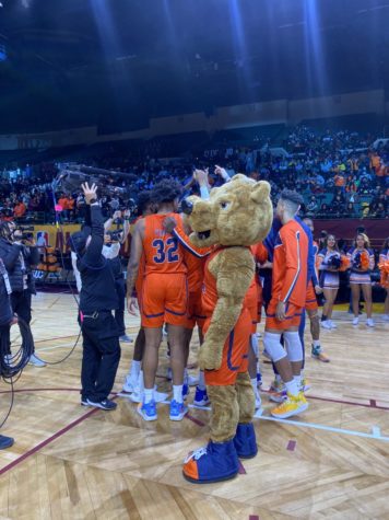 Benny the Bear joins the huddle before the Bears begin to play.