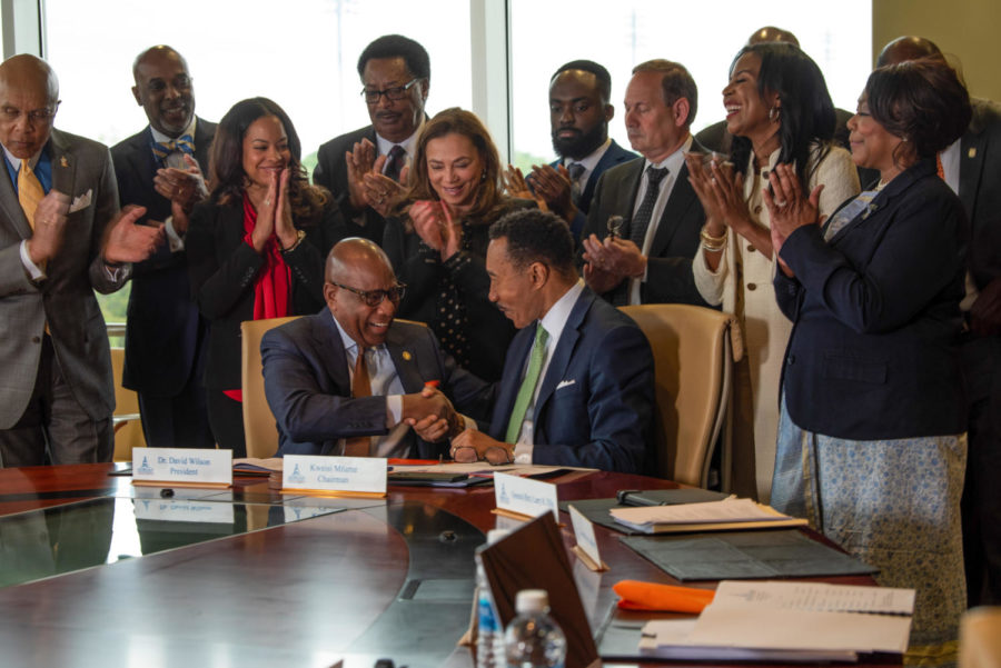 President David K. Wilson shakes hand of Board Chair Kweisi Mfume following official contract signing.