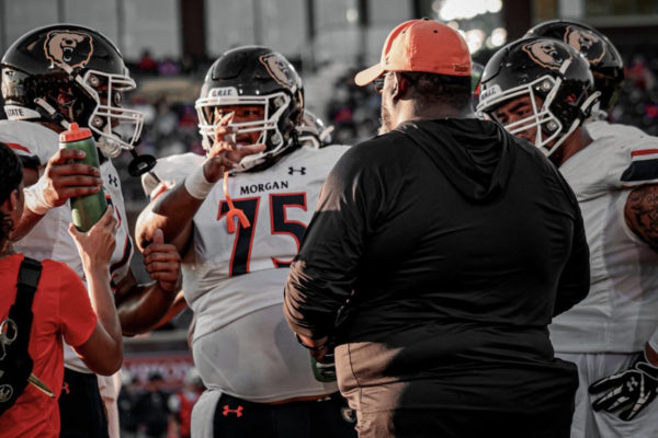 Head Coach Damon Wilson speaks to several members of the offensive line: junior Treyvon Branch (left), senior Dexter Carr Jr. (middle), and senior Marvin Atuatasi (right).