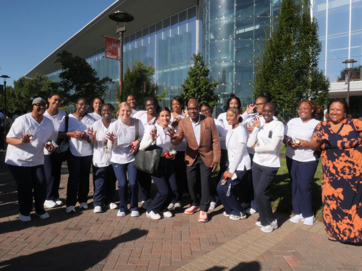 President David K. Wilson posing with nursing students 