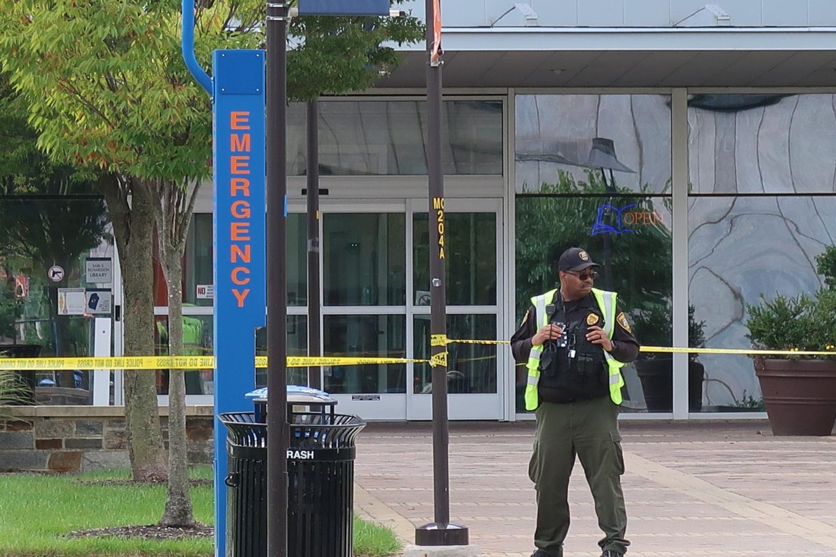 A campus police officer stands guard behind police tape outside the Earl S. Richardson Library after a bomb threat forced the building’s evacuation on Tuesday.