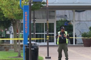 A campus police officer stands guard behind police tape outside the Earl S. Richardson Library after a bomb threat forced the building’s evacuation on Tuesday.