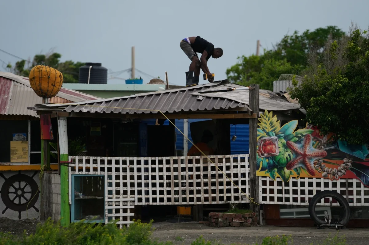 A man fortifies a roof ahead of the forecast arrival of Hurricane Melissa in Kingston, Jamaica, Sunday, Oct. 26, 2025.